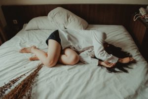 疲れて落ち込み、ベッドに横たわる女性